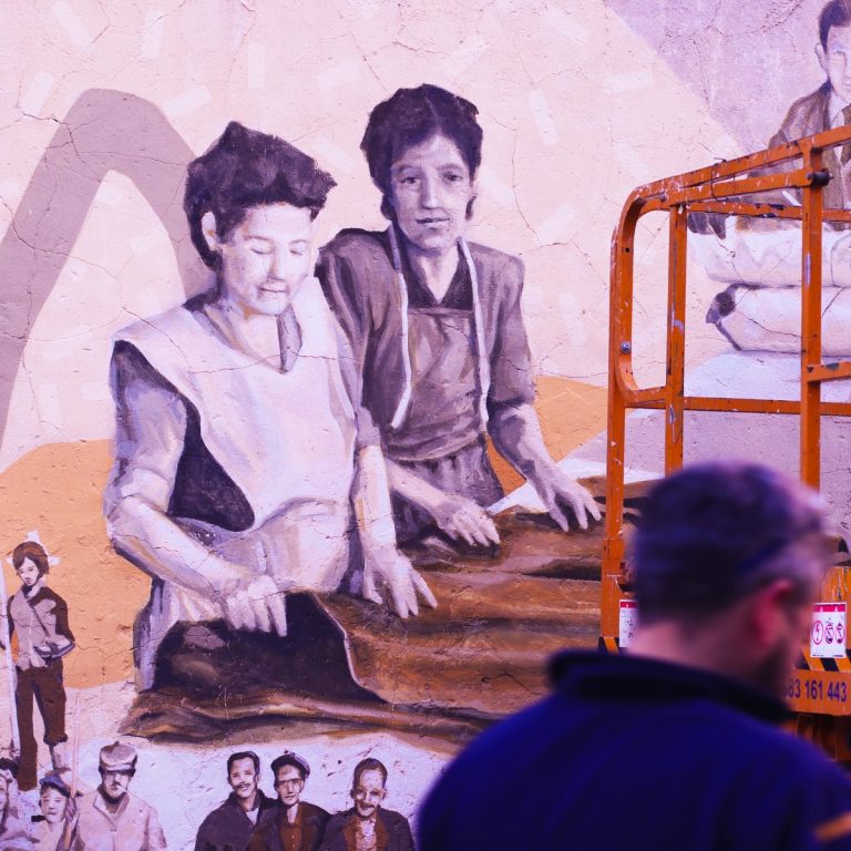Un trabajador pasea por delante del mural homenaje a las mujeres zapateras