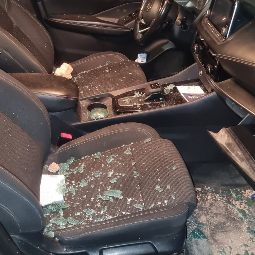 Interior de uno de los coches con las piedras utilizadas para romper los cristales dentro